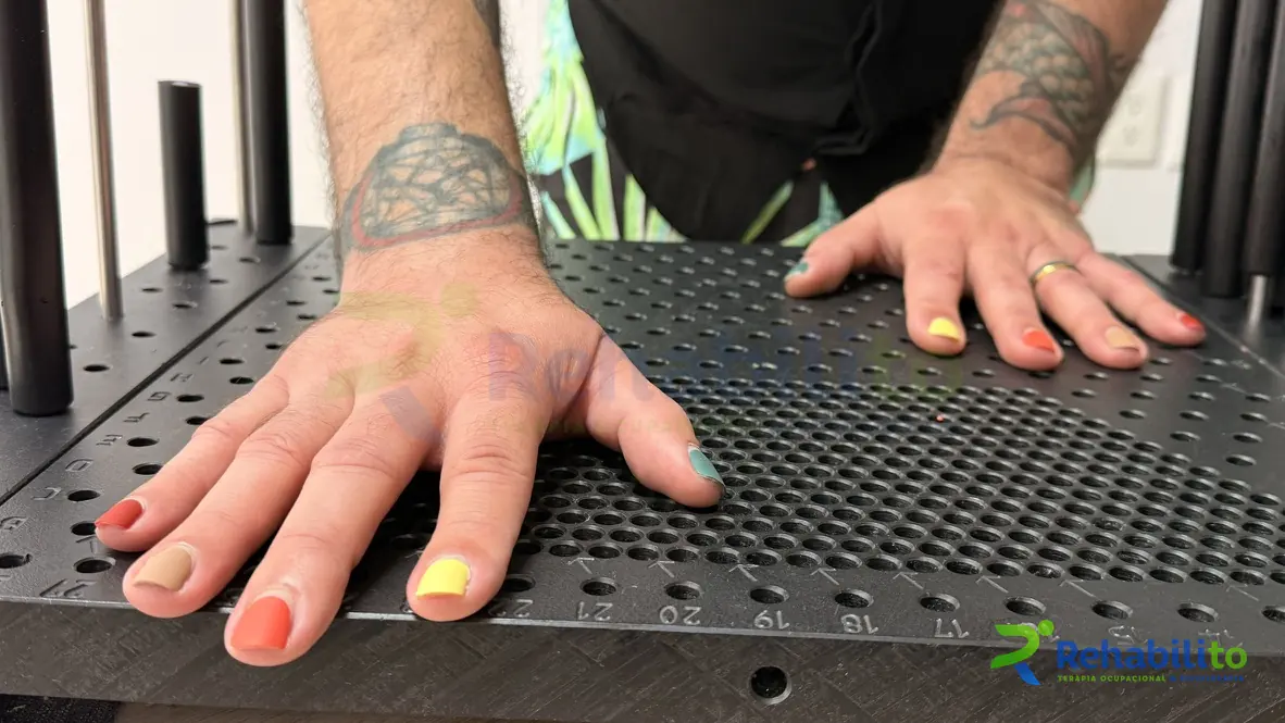 Ambas manos apoyadas sobre una tabla canadiense negra, ejercicio de apoyo palmar y extensión de dedos