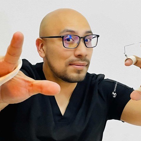 Josué Vargas, terapeuta de mano y extremidad superior y director de RehabiliTO, mostrando órtesis de dedo a la medida